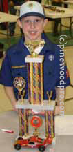 pinewood derby winner with car and trophy