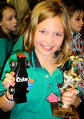 girl pinewood derby winner with trophy picture