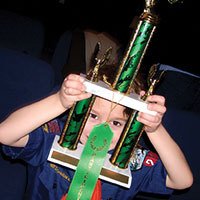 cub scout looking at trophy cub scout looking at trophy