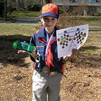 cub scout holding pinewood derby trophy