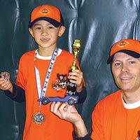 Proud cub scout with car, dad, and trophy